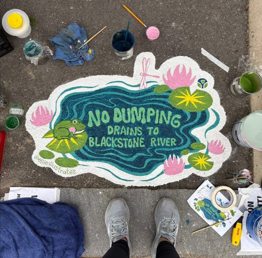 Mural identical to the previous image, but shown mid-painting with surrounding supplies, including paint cans and brushes. The artist’s feet are visible above the artwork.