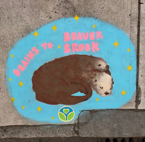 Sidewalk painting of two cuddling otters surrounded by small yellow stars with the words “Drains to Beaver Brook” in pink letters on a light blue background.