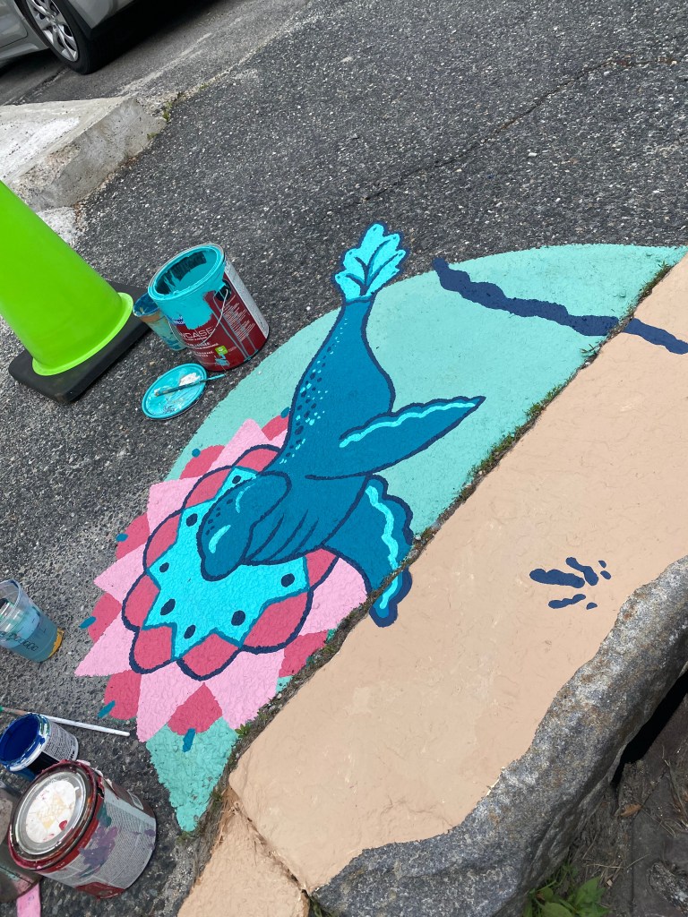 Another in-progress shot of the mural with the seal silhouette filled in and the surrounding mandala pattern being detailed.