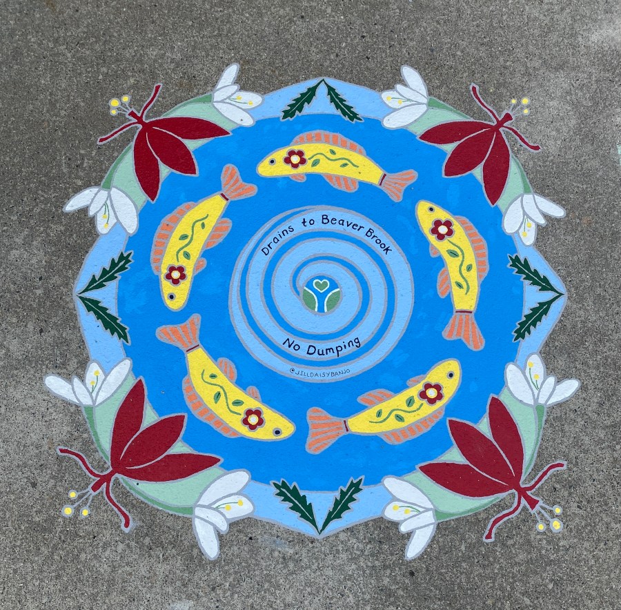 Vibrant circular mural with concentric rings of swimming yellow fish, surrounded by red flowers and white blossoms. The text in the center reads “Drains to Beaver Brook – No Dumping.”